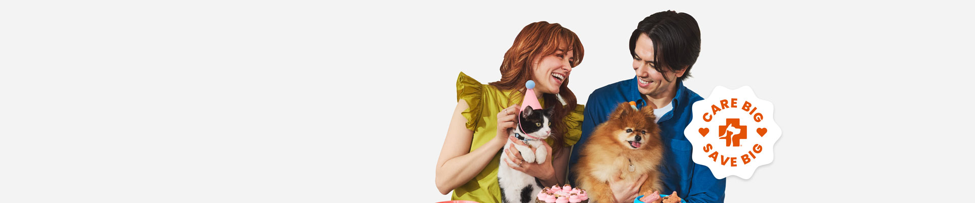 A man holding a dog and a woman holding a cat sitting next to each other