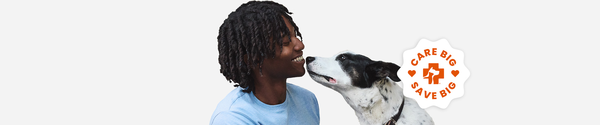 A black and white dog sniffing his smiling owner's mouth